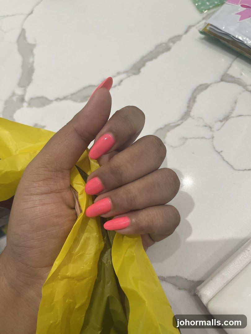 Hand with Pink Nails Holding Yellow Bag