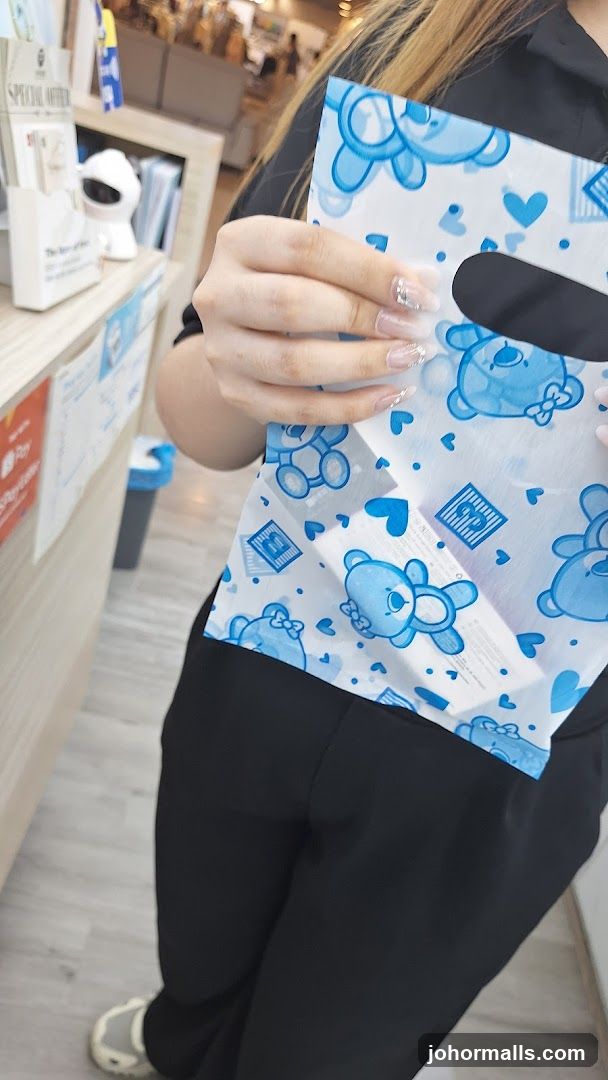 Person holding a shopping bag with teddy bear print
