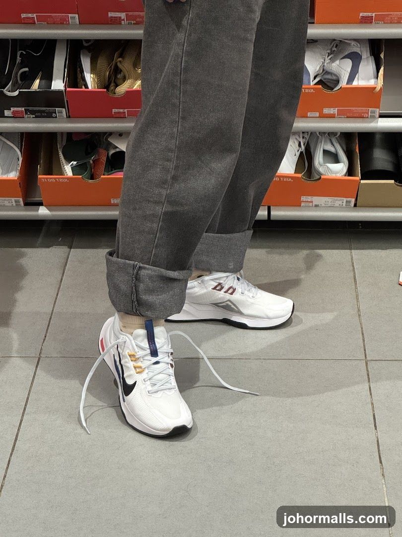 Person wearing white sneakers in a shoe store