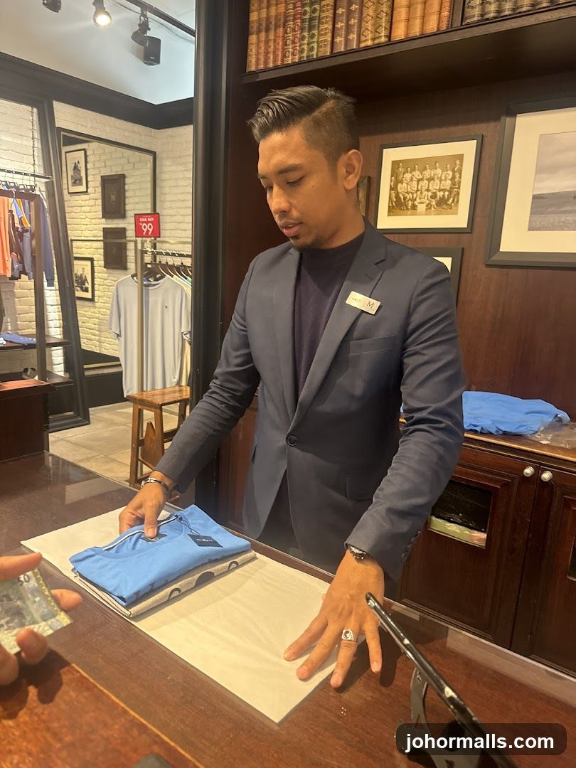 Salesperson folding a shirt at a counter