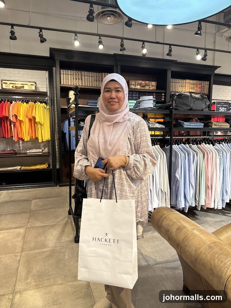Woman holding a Hackett shopping bag in a clothing store