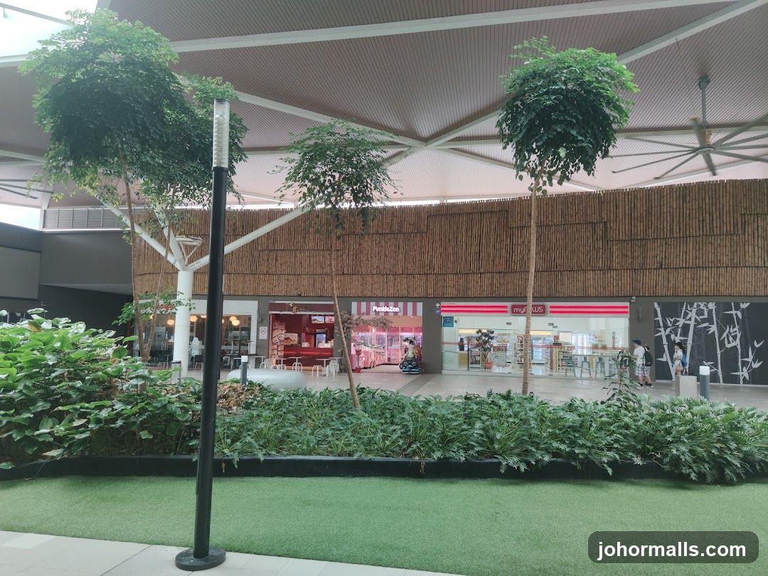 Indoor shopping area with greenery and shops