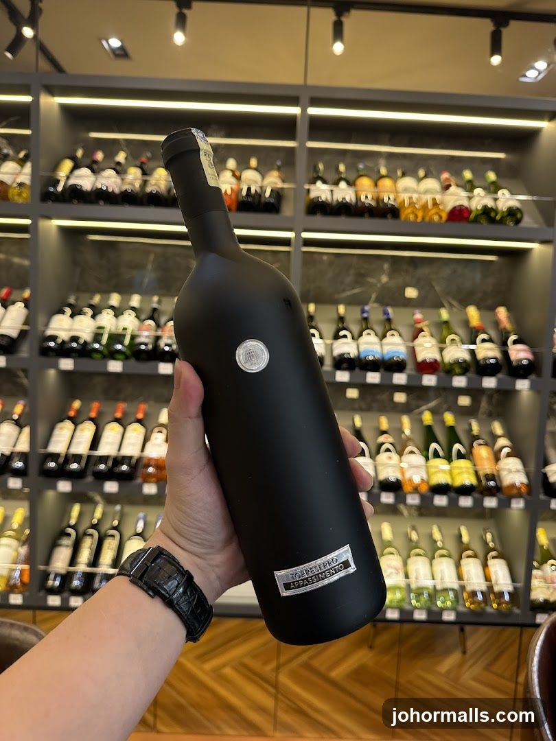 Person holding a bottle of wine in a wine shop