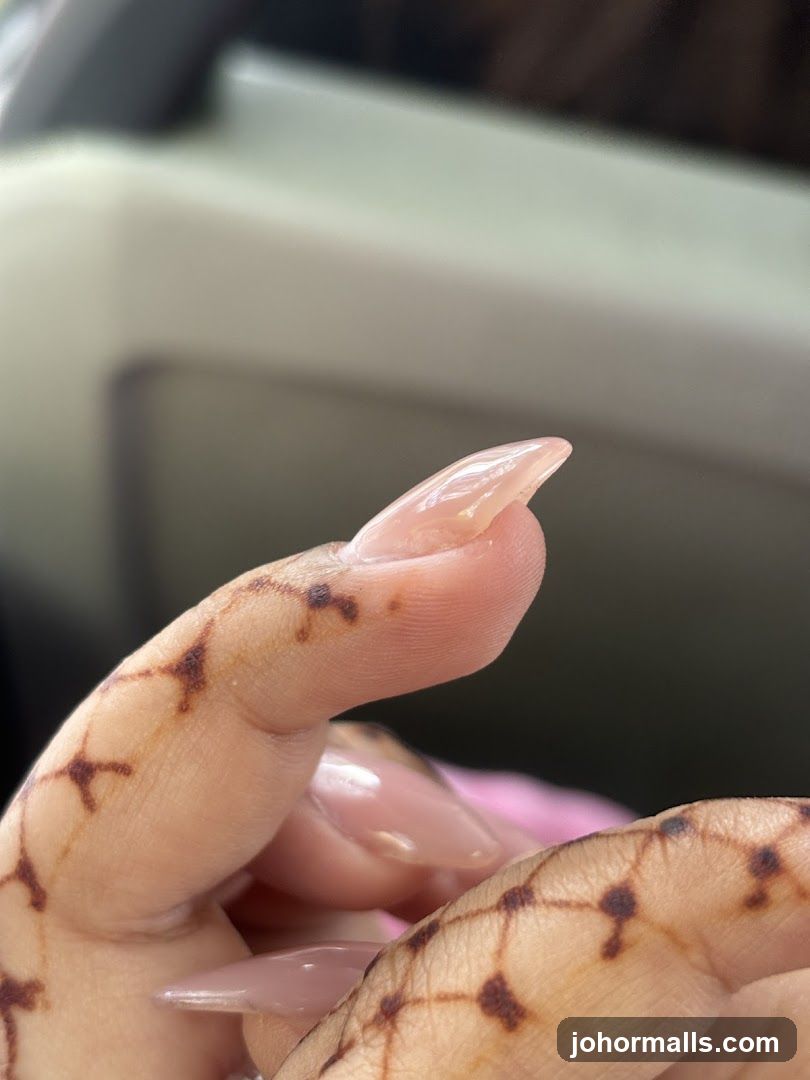 Close-up of a hand with henna designs and acrylic nails