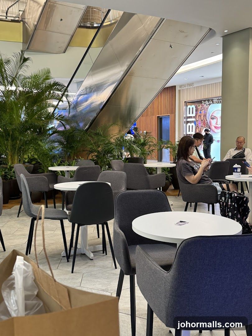 Indoor seating area with escalators and plants