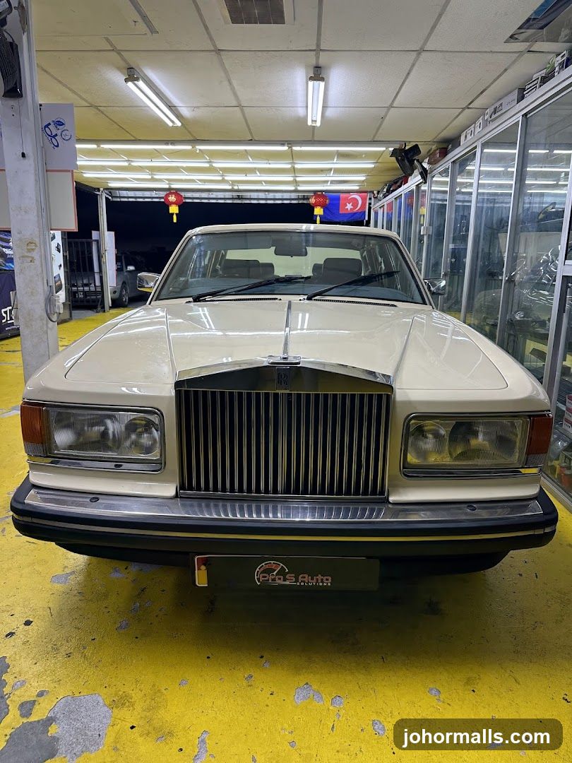 Cream-colored Rolls-Royce in a garage