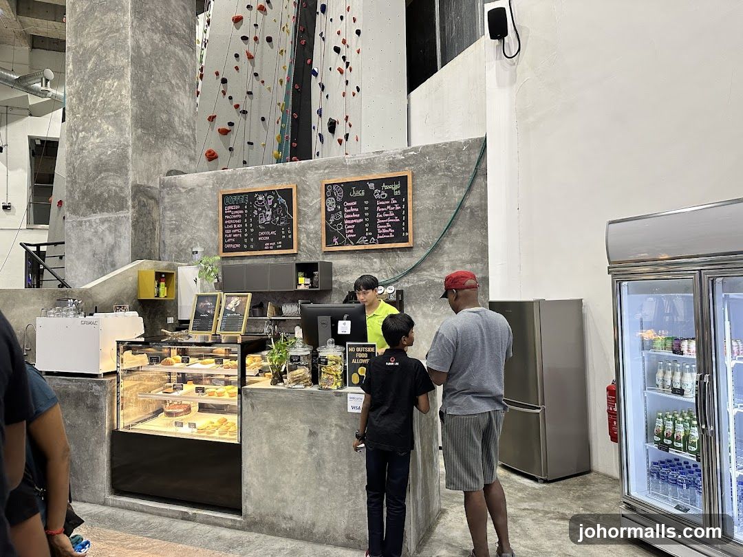 Indoor café area with climbing wall background