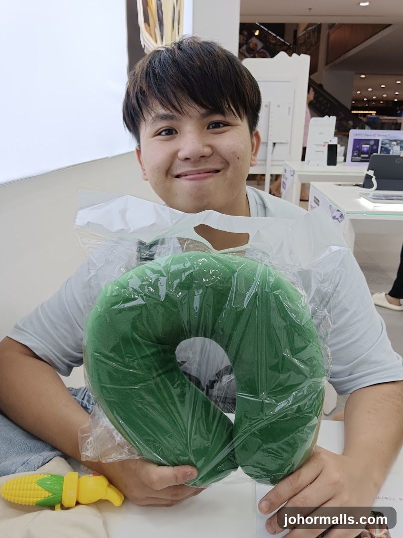 Person holding green neck pillow in store interior