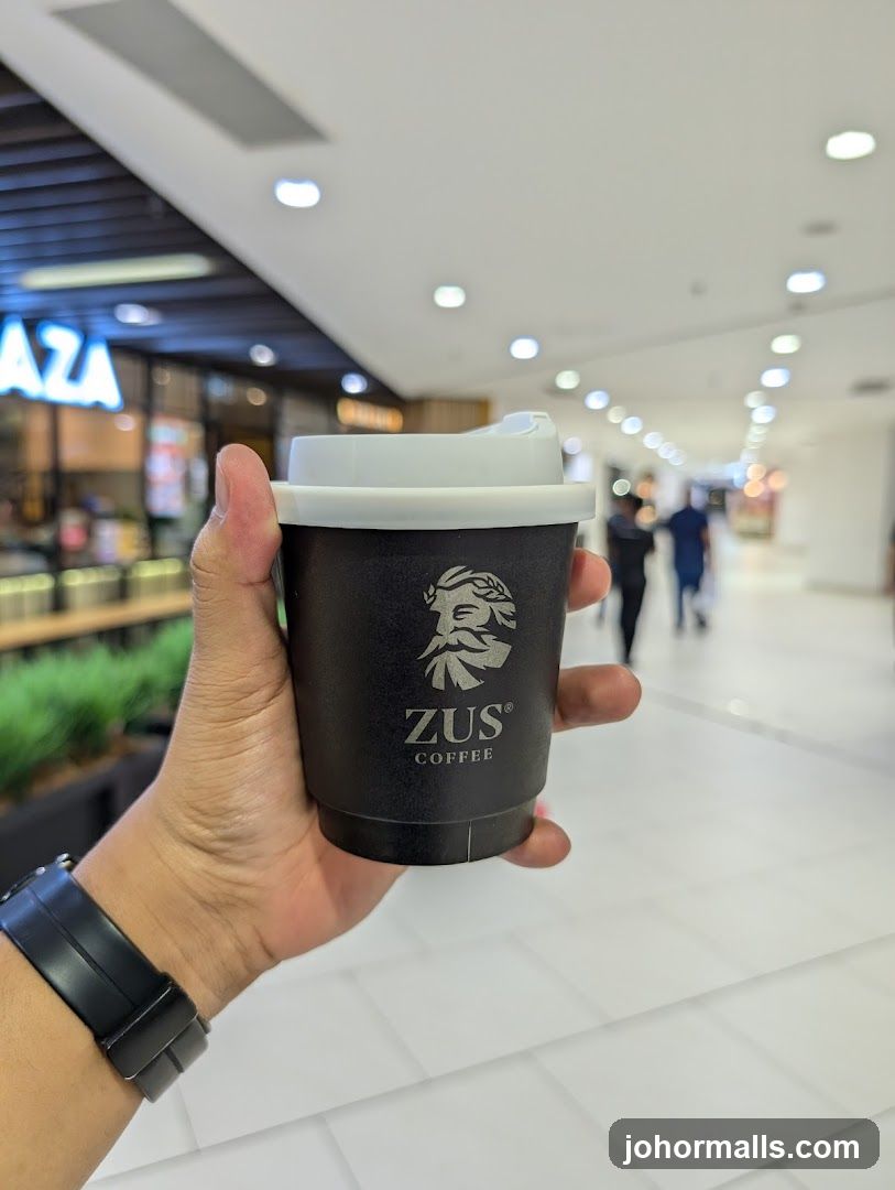 Hand holding coffee cup in shopping mall