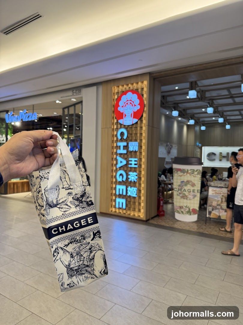 Hand holding Chagee bag in front of store entrance