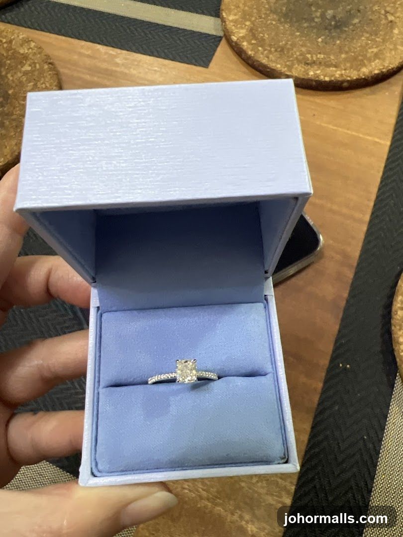 Hand holding diamond ring in box