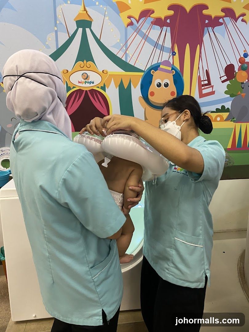 Staff assisting baby in children's facility