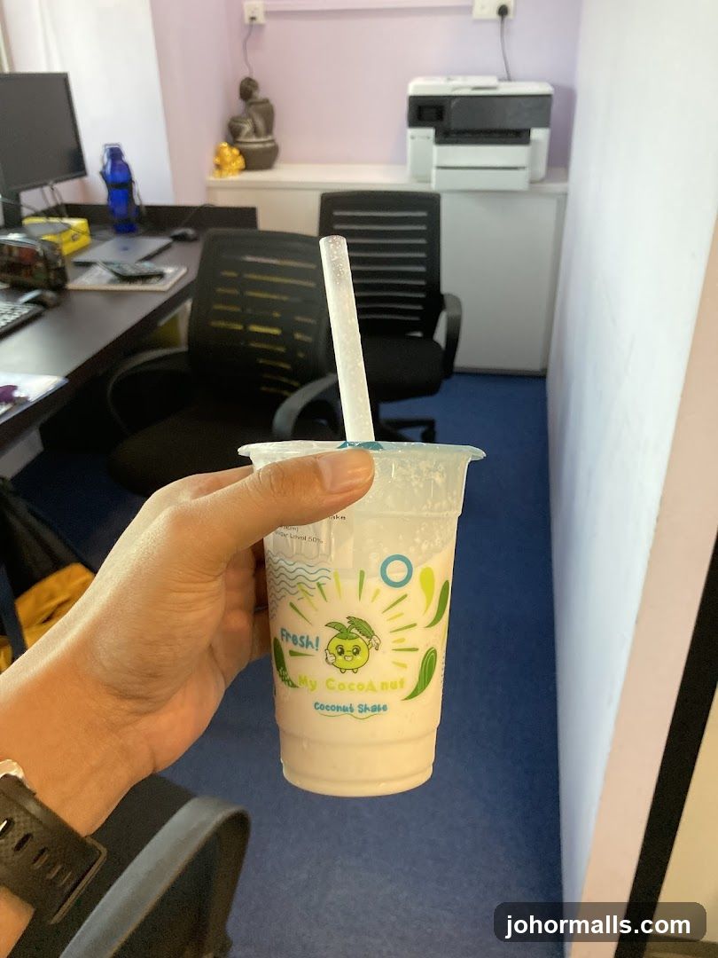 Hand holding coconut shake in office
