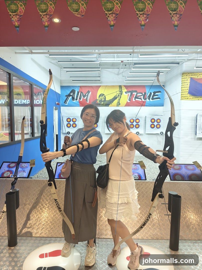 Two women at indoor archery range