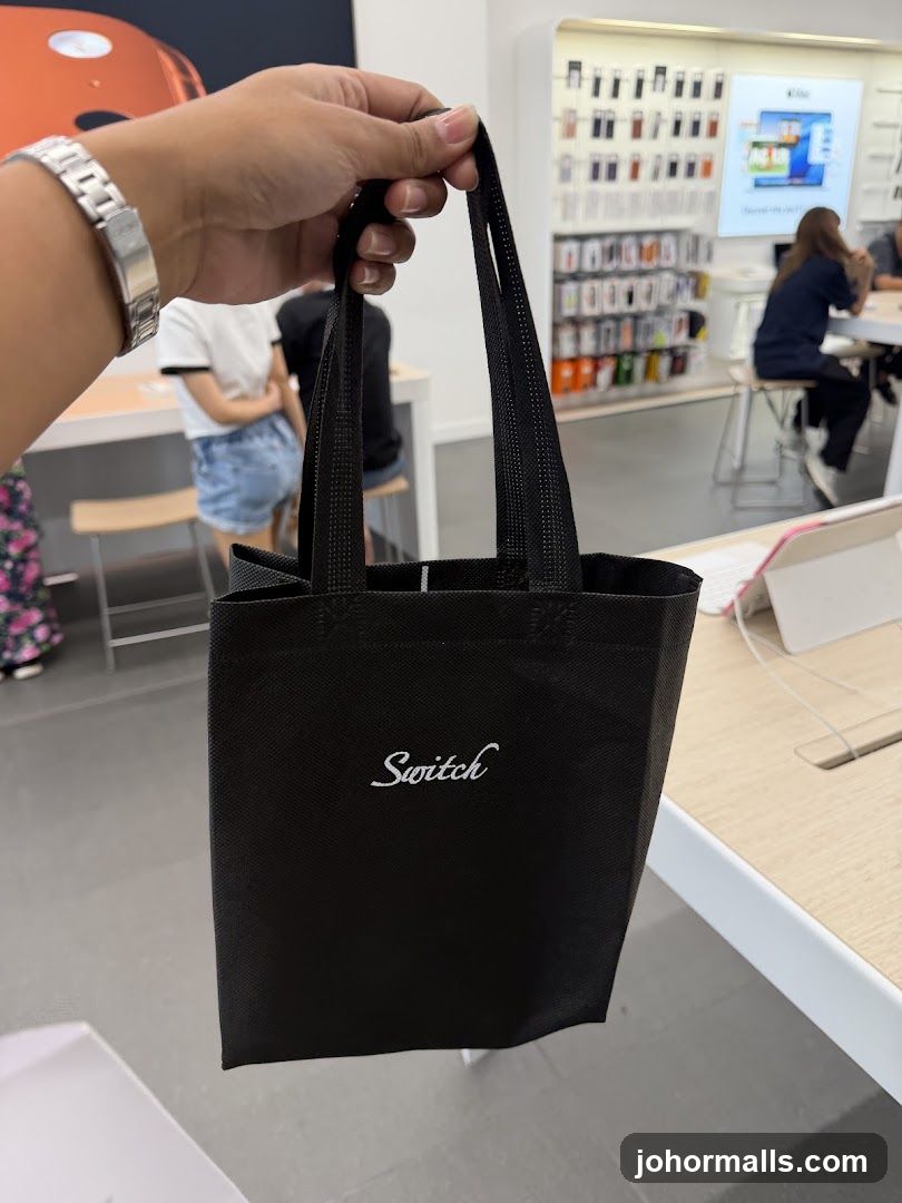 Hand holding branded tote bag in store interior