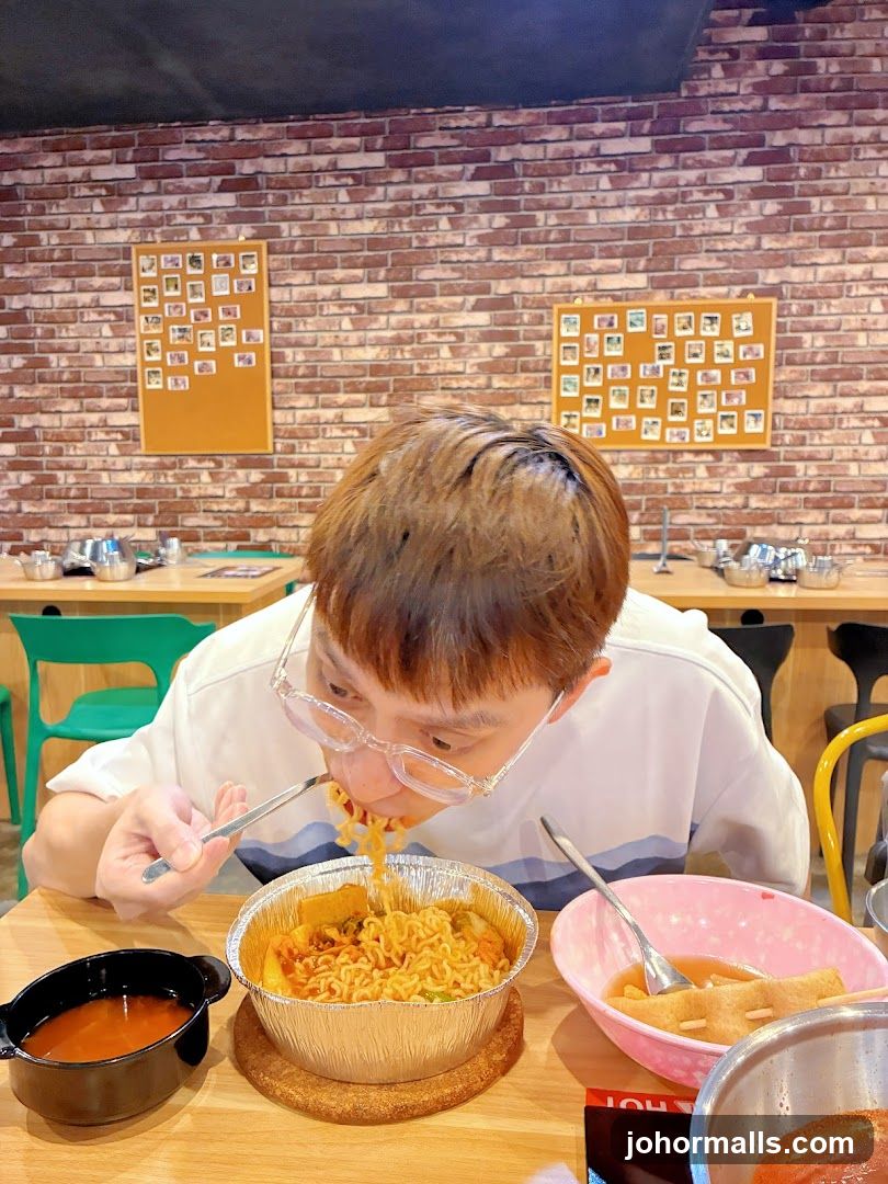 Person Eating Noodles in Restaurant