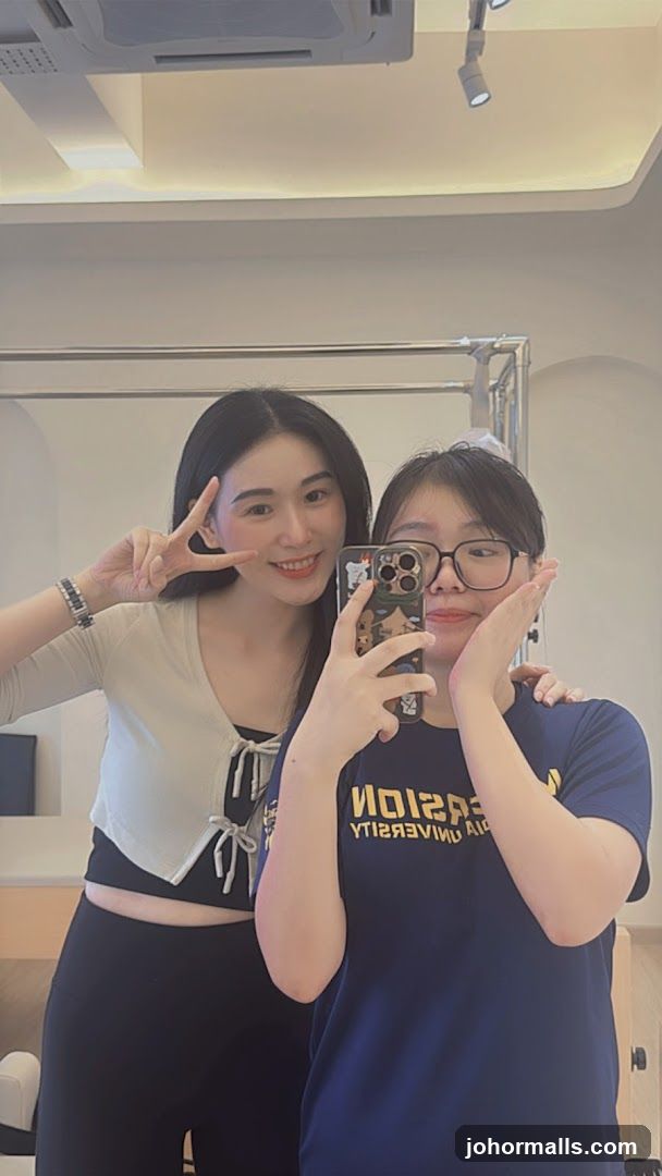 Two individuals taking selfie in indoor setting