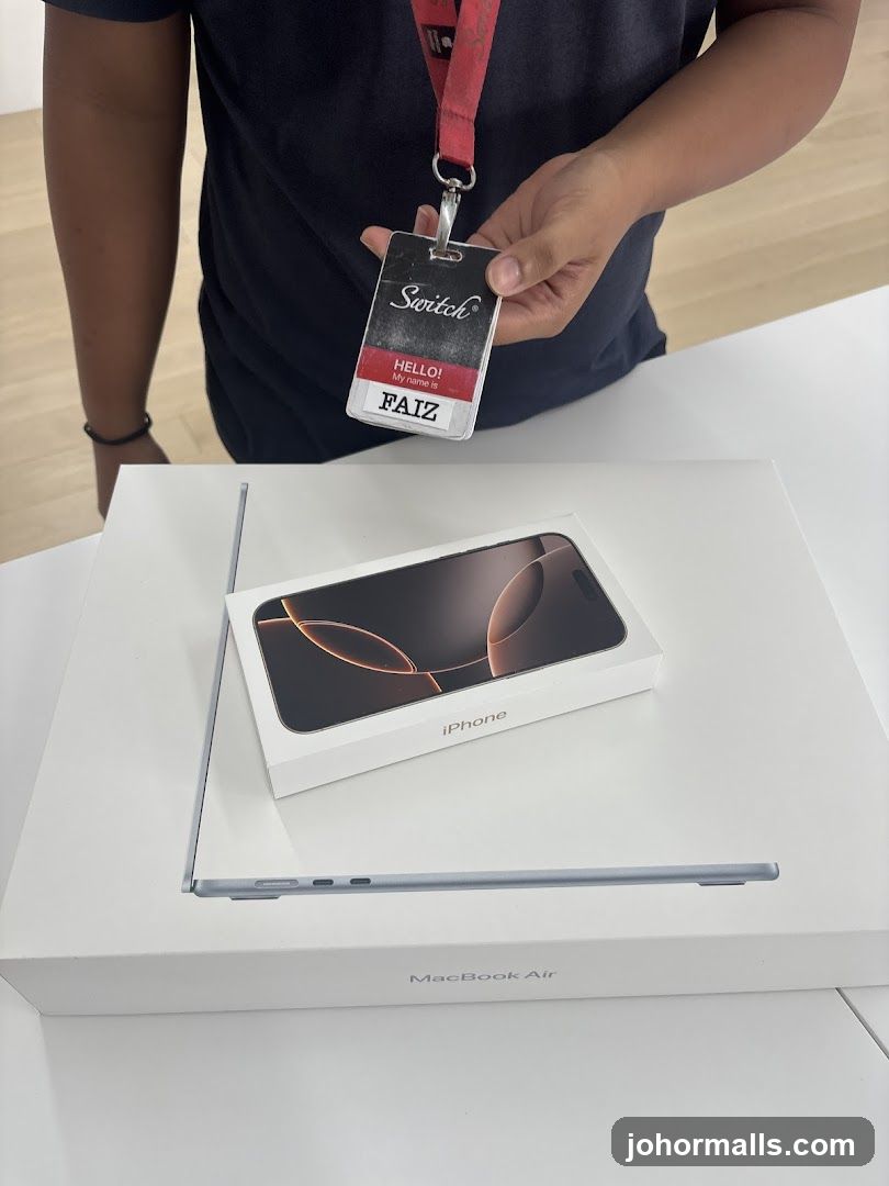 Staff holding ID badge with Apple products on display