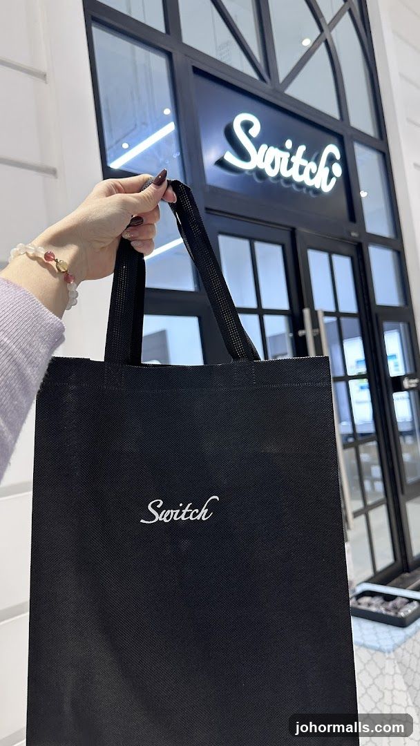 Hand holding Switch bag in front of store entrance