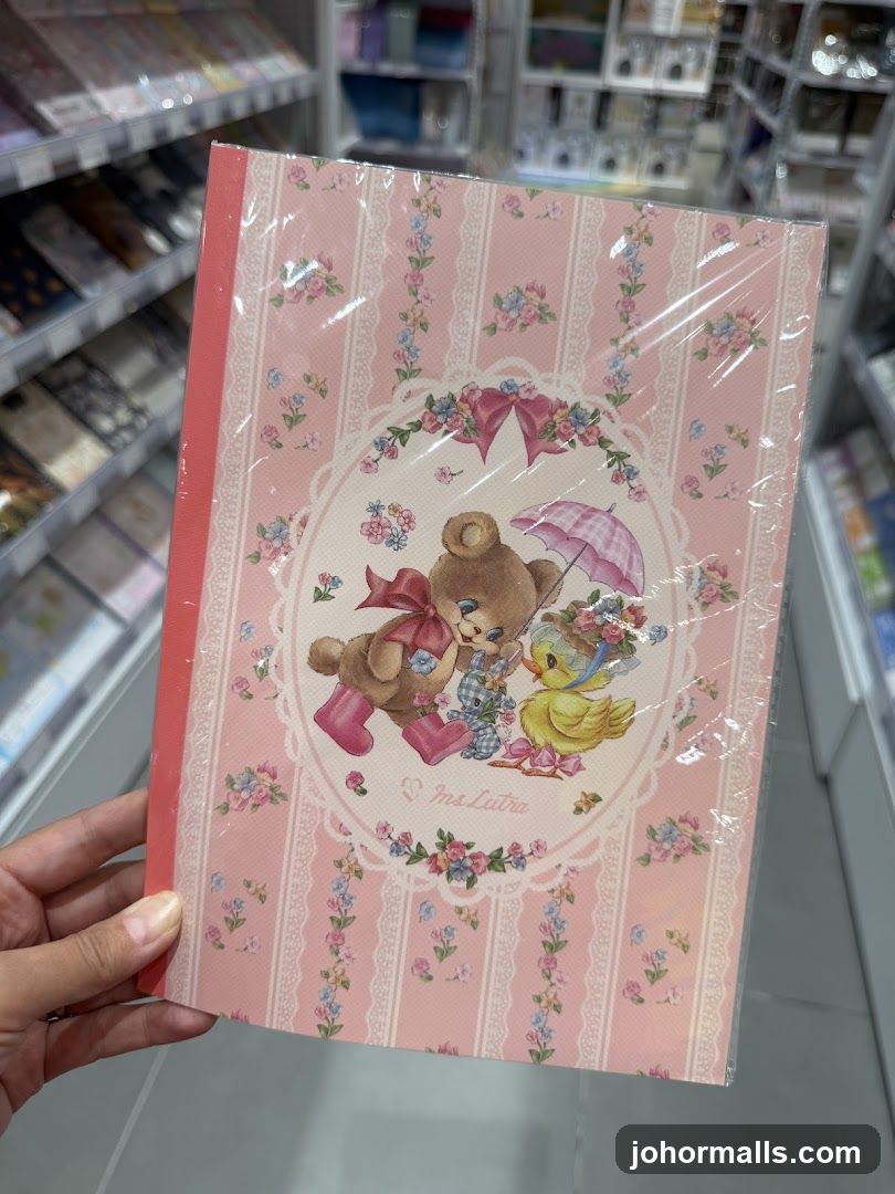 Hand holding a pink floral notebook