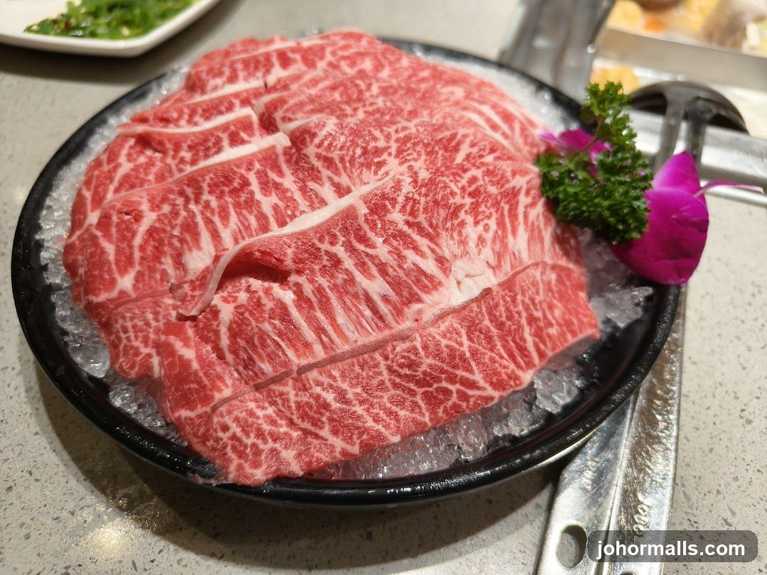 Raw beef slices on ice with garnish