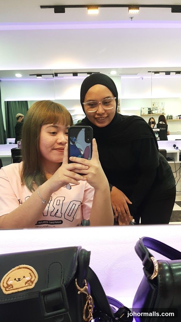 Two women taking selfie in salon mirror