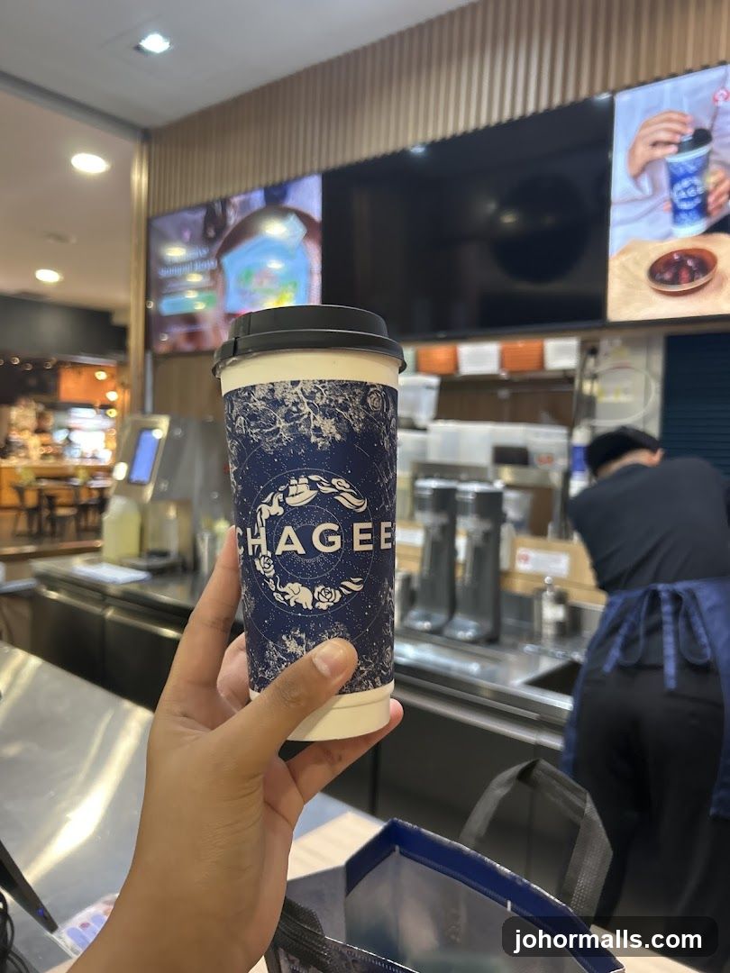 Hand holding beverage cup inside café