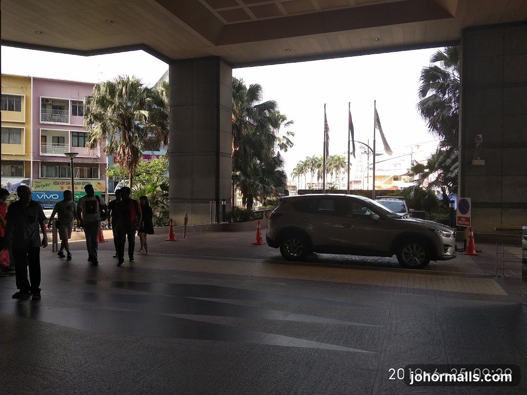 People walking under a covered walkway with cars and buildings in the background