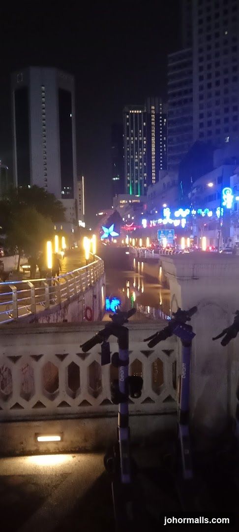 Cityscape at Night with River and Scooters