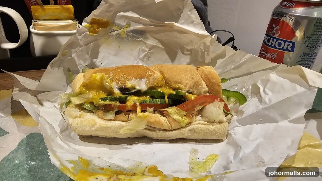 Sub sandwich with toppings and a can of Anchor beer