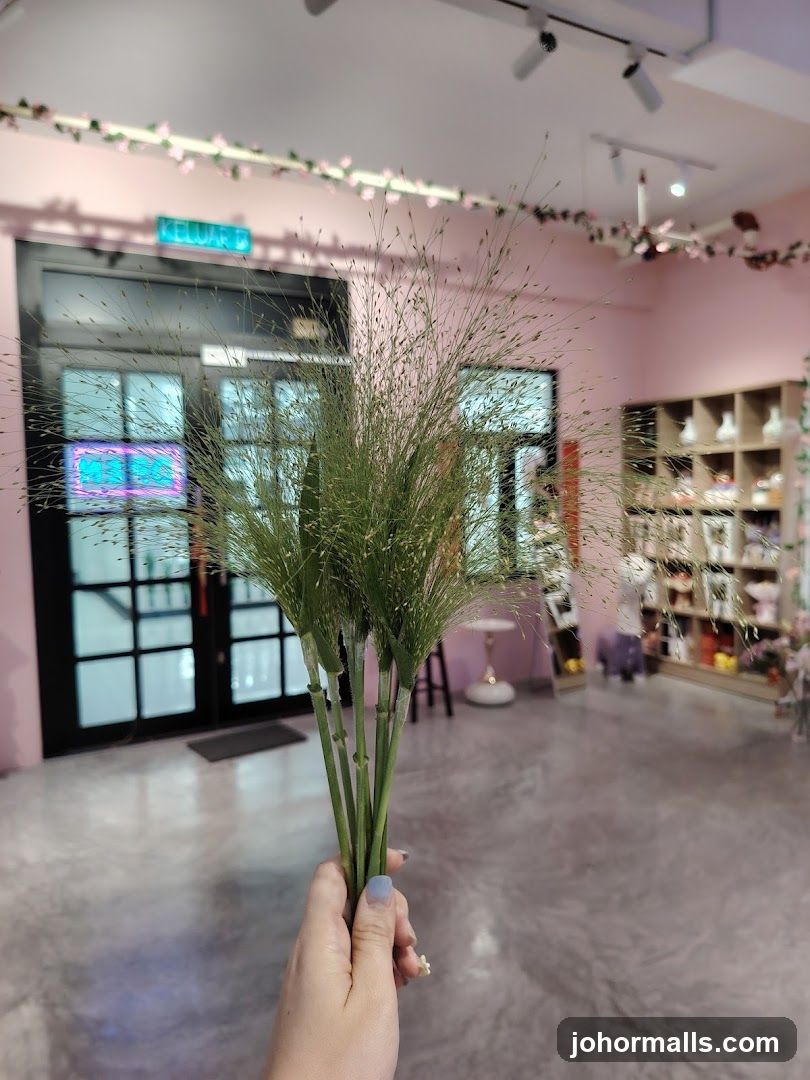 Hand holding dried grass in a flower shop
