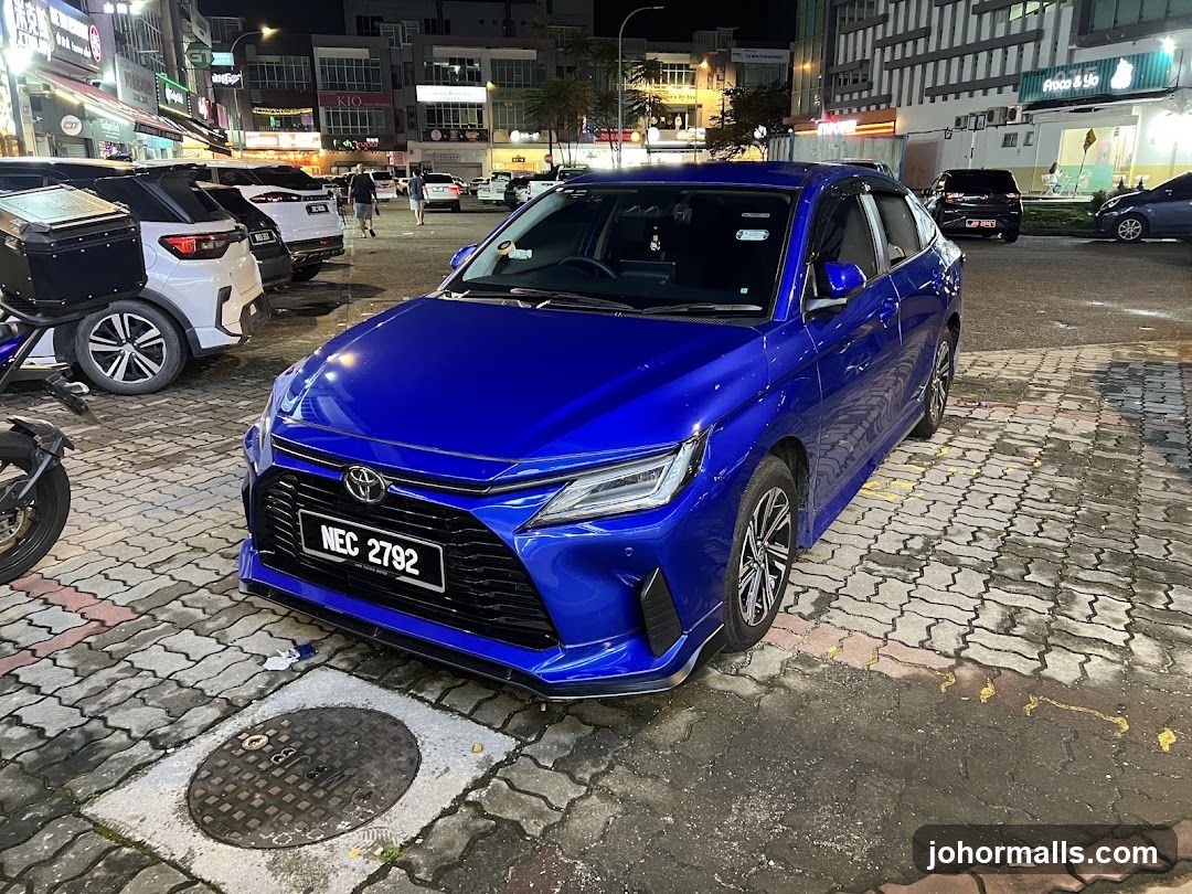 Blue Car Parked on Cobblestone Street at Night