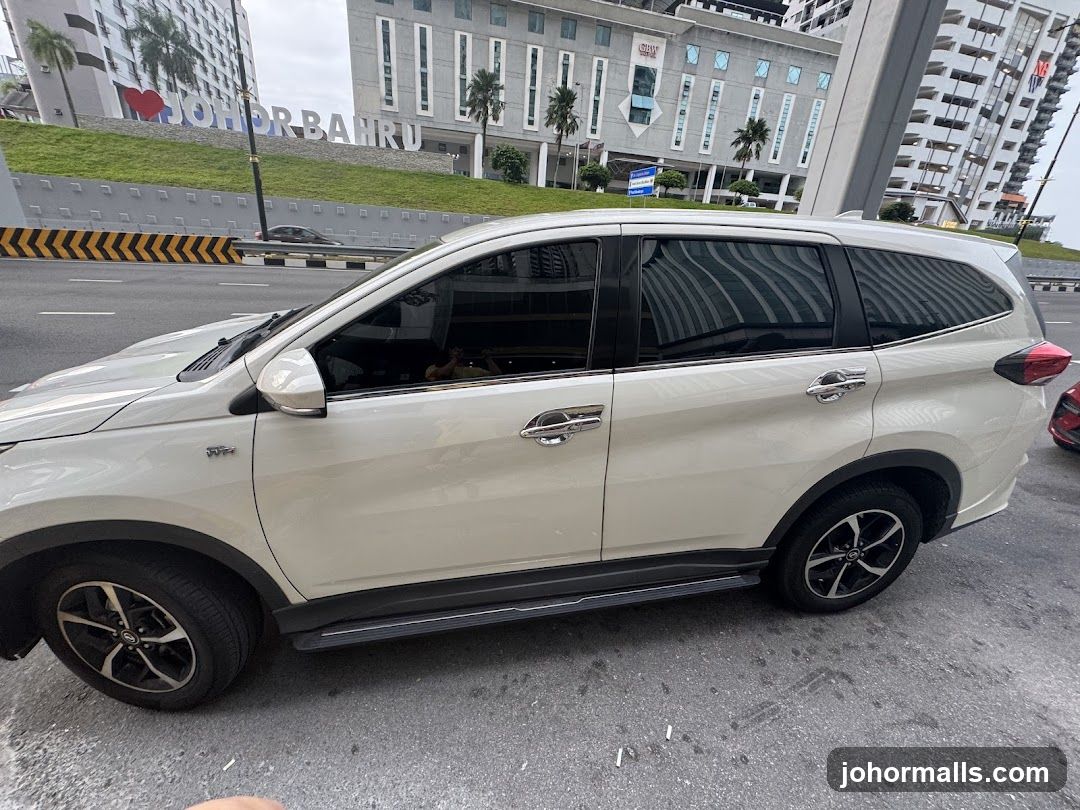 White SUV parked on street with Johor Bahru sign in background