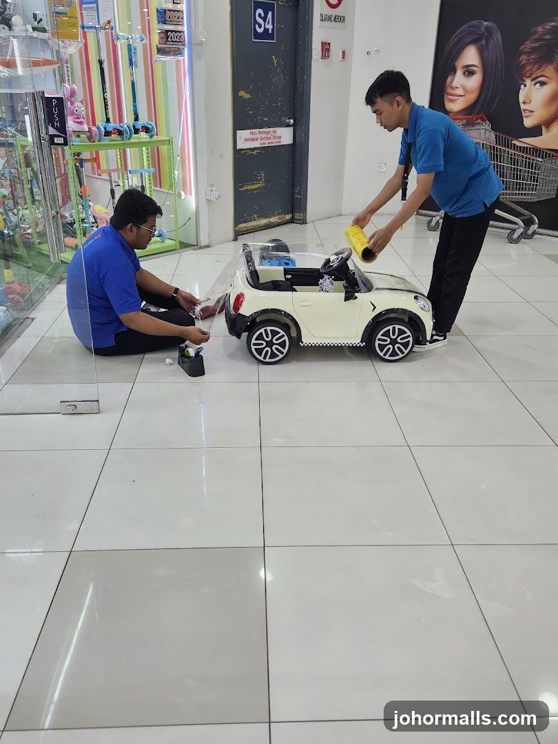 Workers applying protective film to a toy car