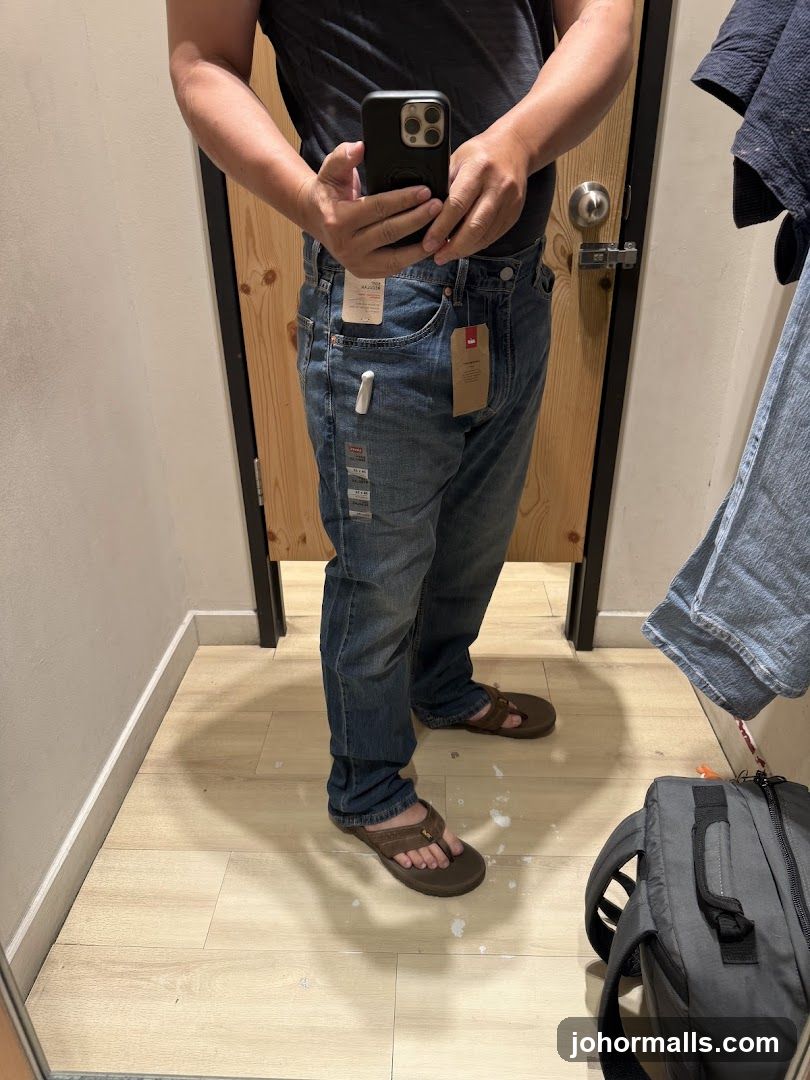 Man trying on jeans in a fitting room