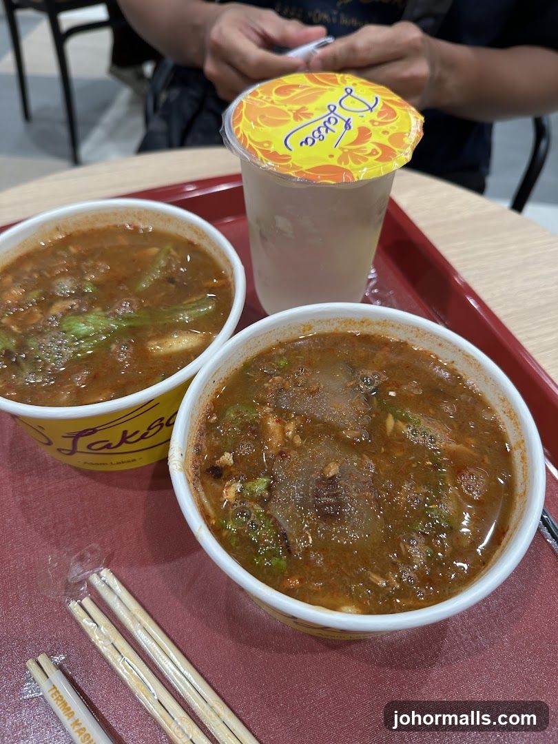 Two bowls of Laksa with a drink