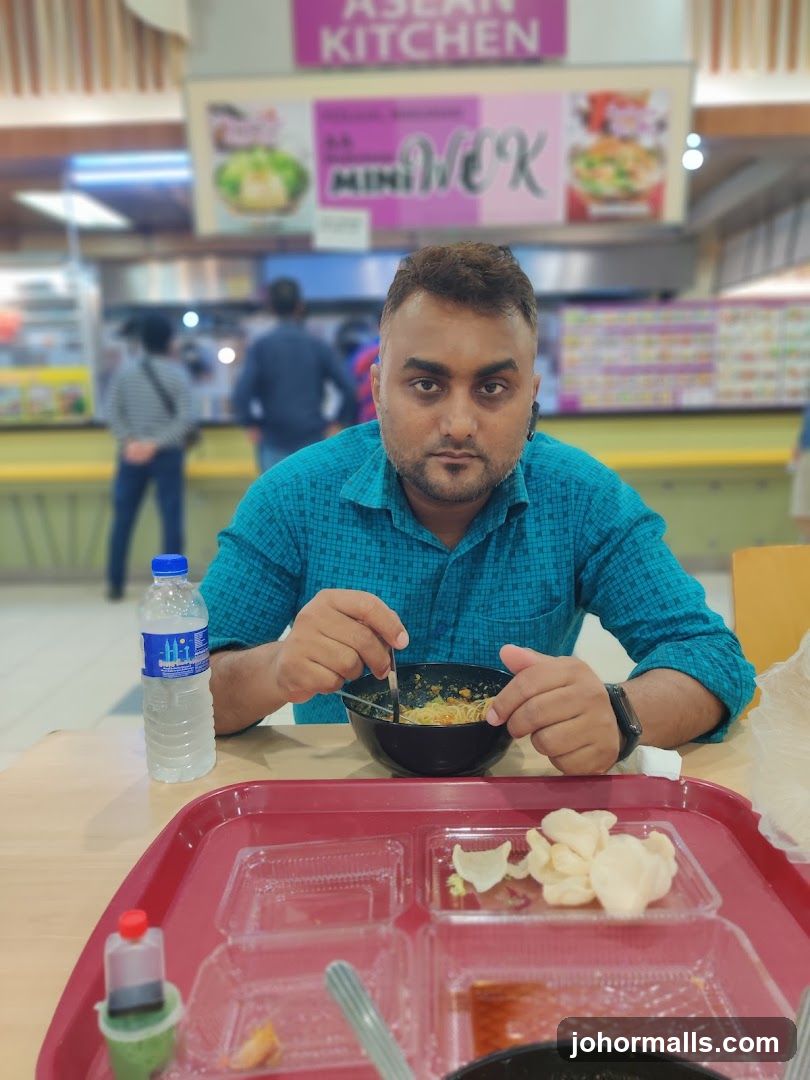 Man eating noodles at a food court