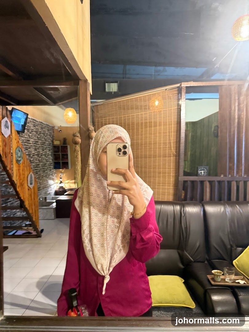 Woman taking a mirror selfie in a cafe