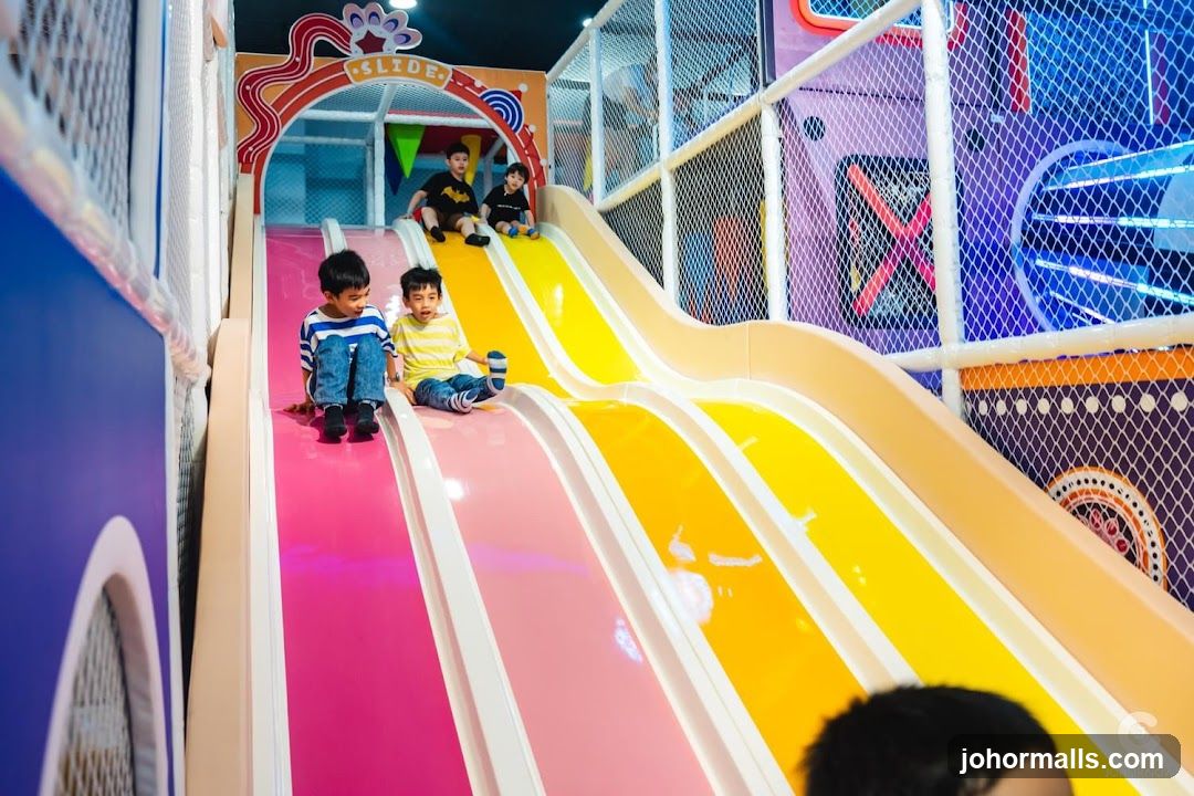 Children Sliding Down a Colorful Playground Slide