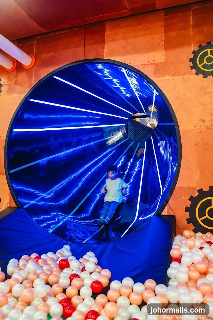 Child on a blue slide in a ball pit