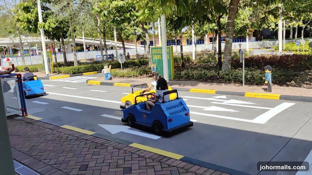 Children driving toy cars in a park