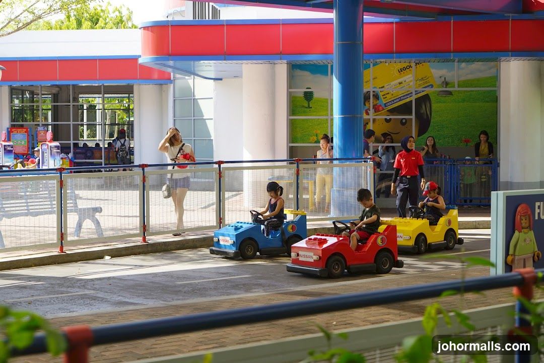Children driving Lego cars at an amusement park