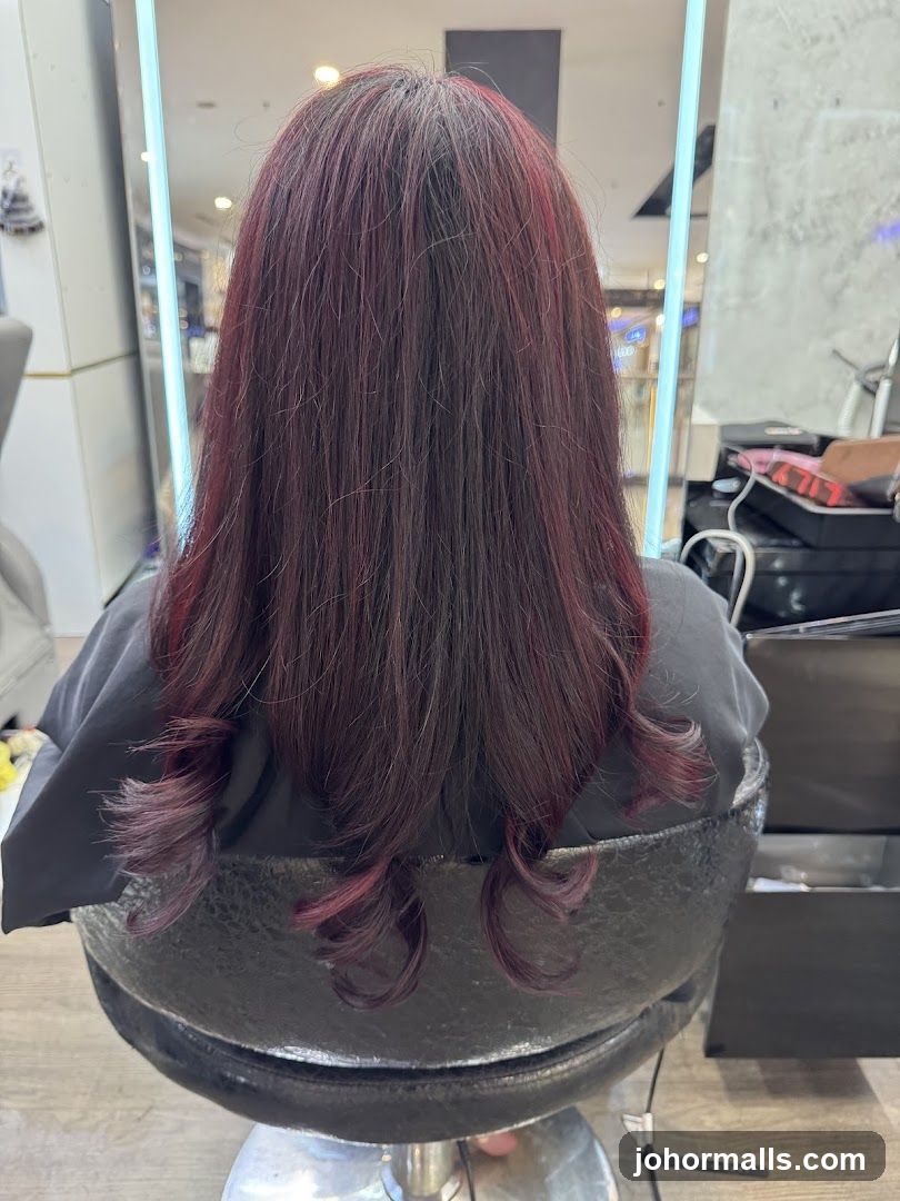 Woman with dark red hair styled in curls