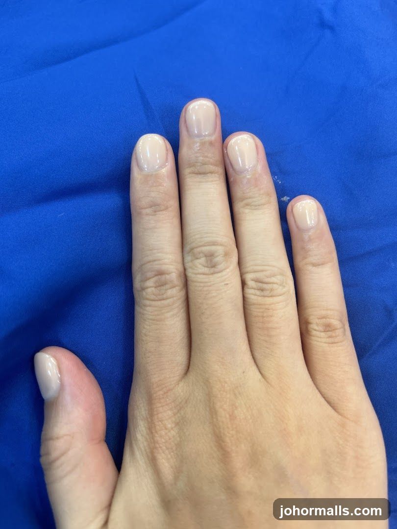Hand with light-colored nail polish