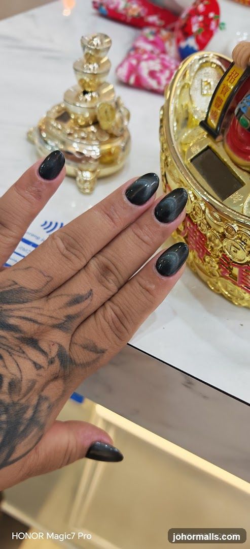 Close-up of a hand with dark, glossy nails