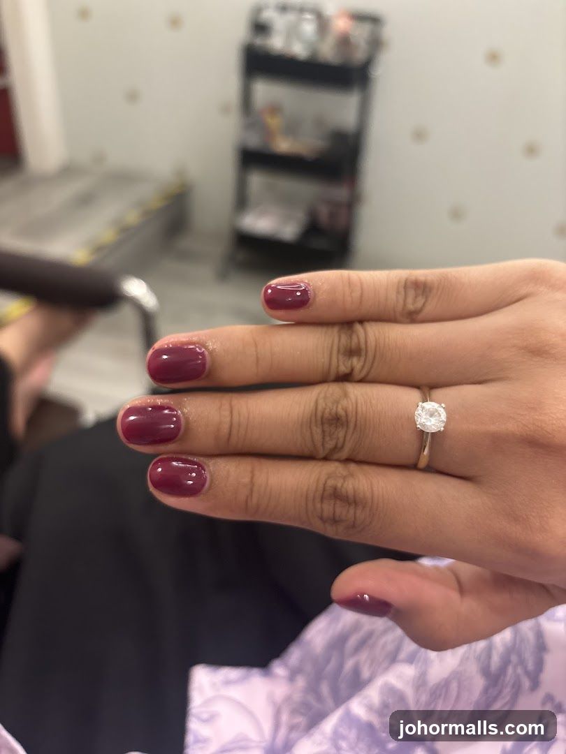 Woman's hand with burgundy nail polish and diamond ring
