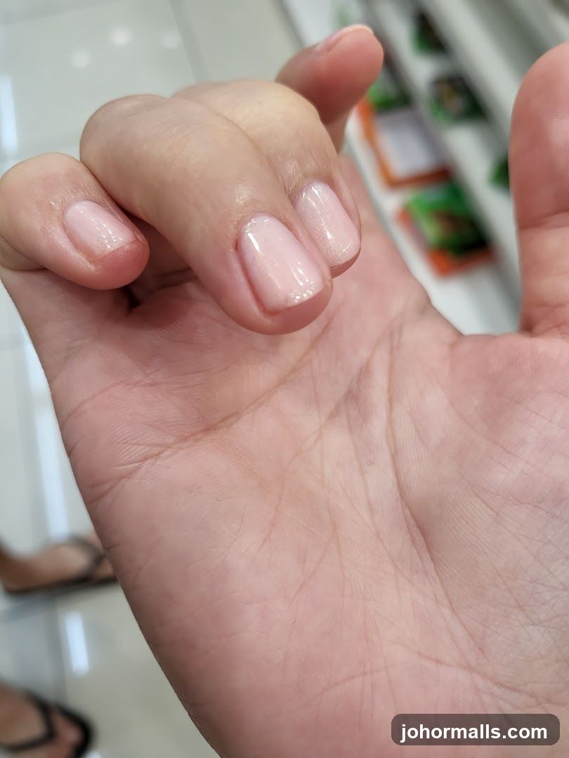 Close-up of a hand with light pink polished nails