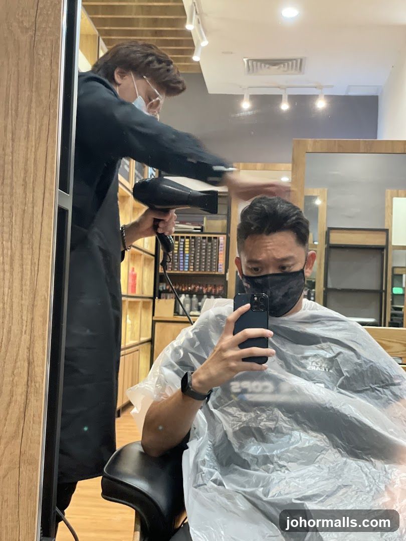 Hairdresser drying client's hair