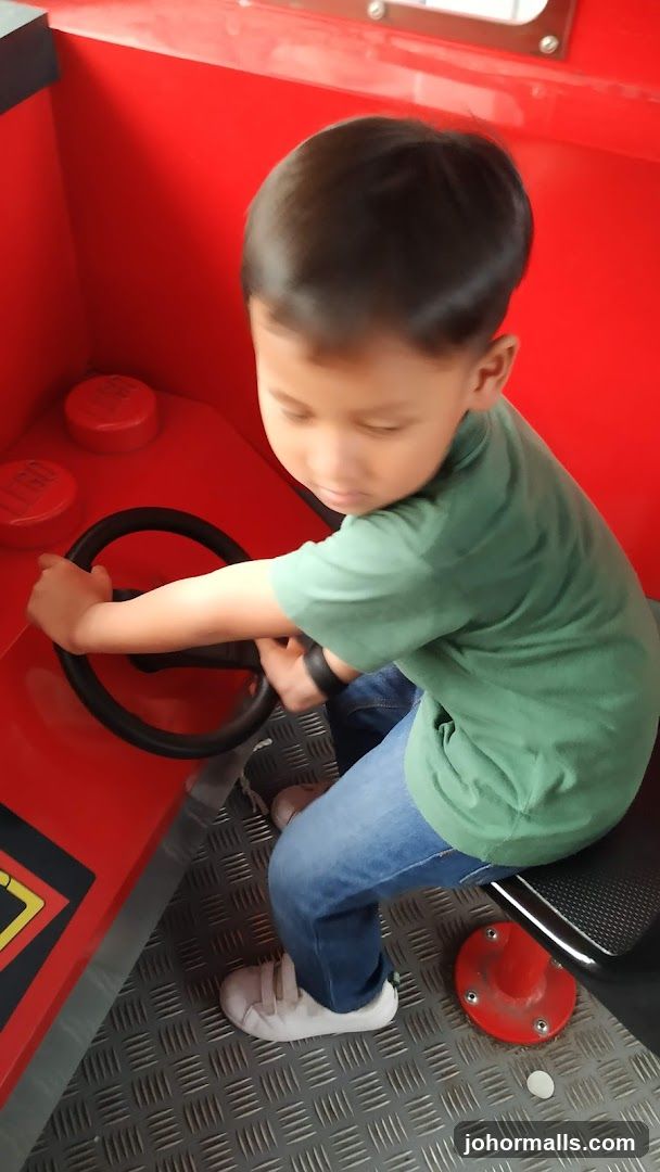 Child playing in a red vehicle-themed play area