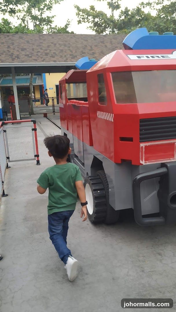 Child approaching a Lego fire truck